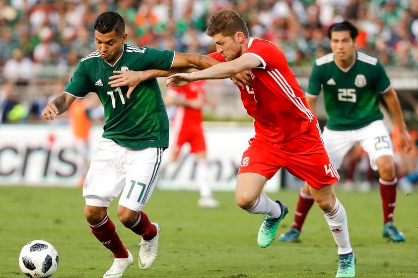 El mexicano Jesús Manuel Corona, izquierda, defiende el balón ante el galés Ben Davies en el...
