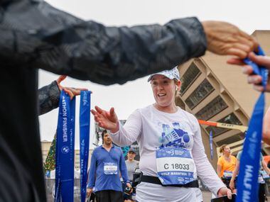 Candace Hupp reaches for her medal after completing the half-marathon at the BMW Dallas...