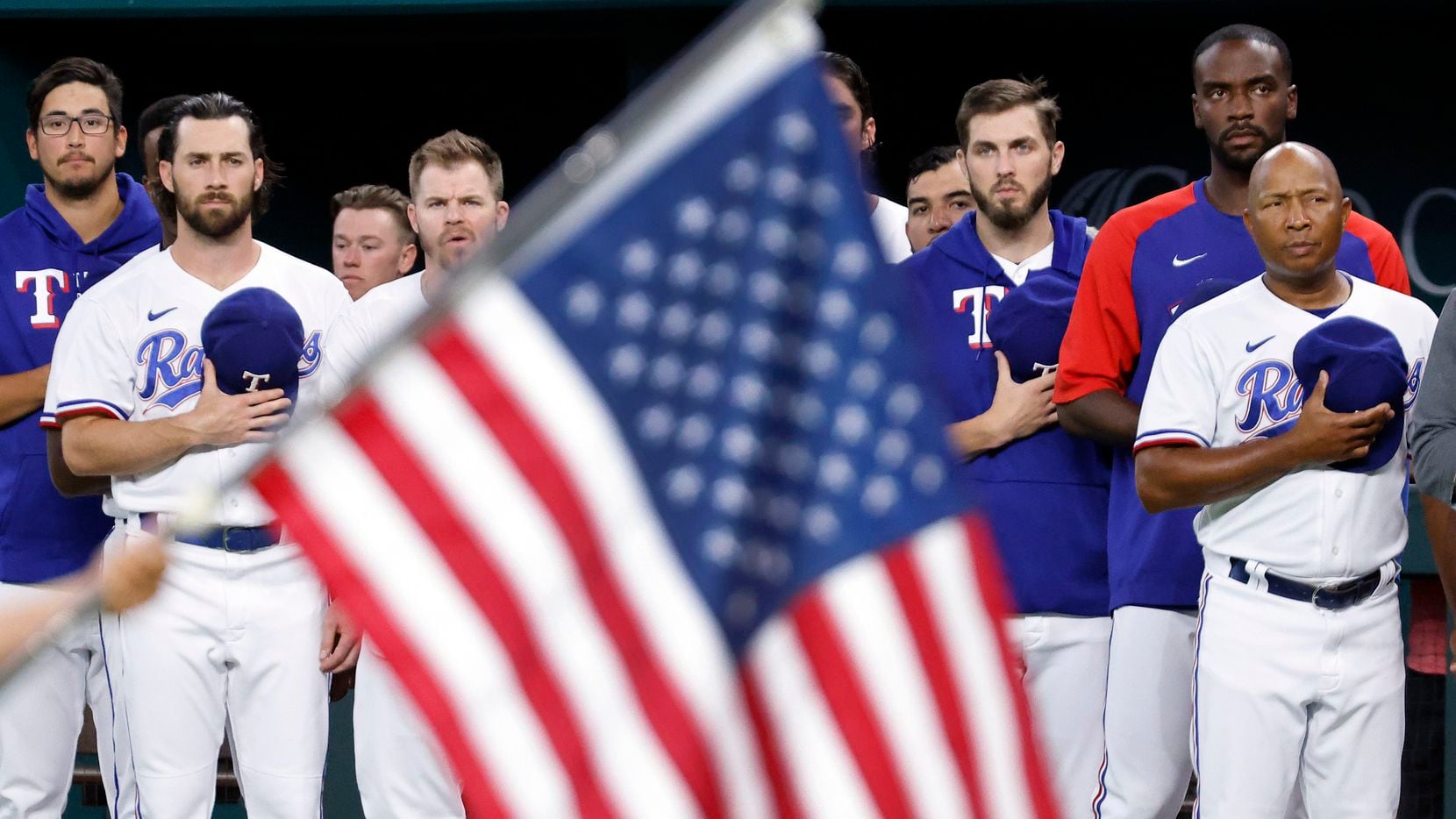 Texas Rangers players and coaches stand for the national anthem during the Texas Rangers...