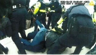 Robert Wayne Dennis is shown above a policeman after taking him to the ground.