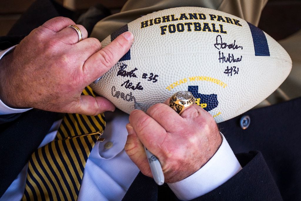 Highland Park head coach Randy Allen autographs a football as the Highland Park football and...