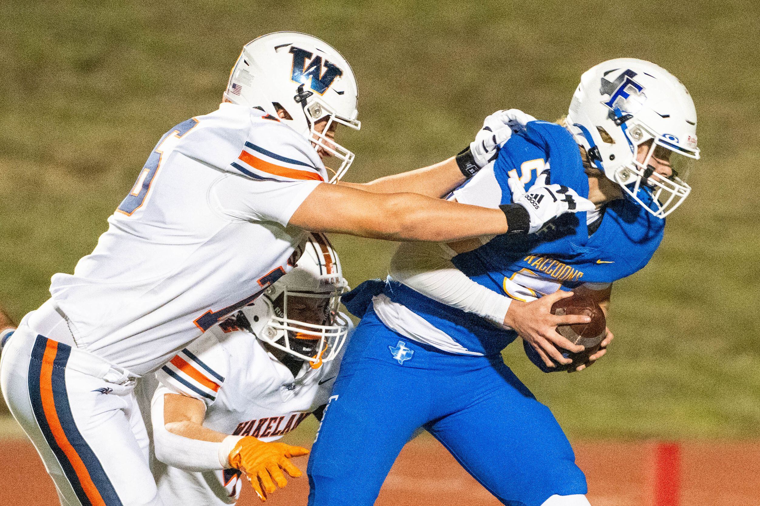 Frisco's Cobyn Harbert (5) escapes the sack attempt by Wakeland's Tristan Simmons (6) and...