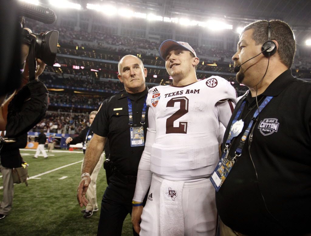 Texas A&M Aggies quarterback Johnny Manziel (2) is escorted to the trophy presentation at...