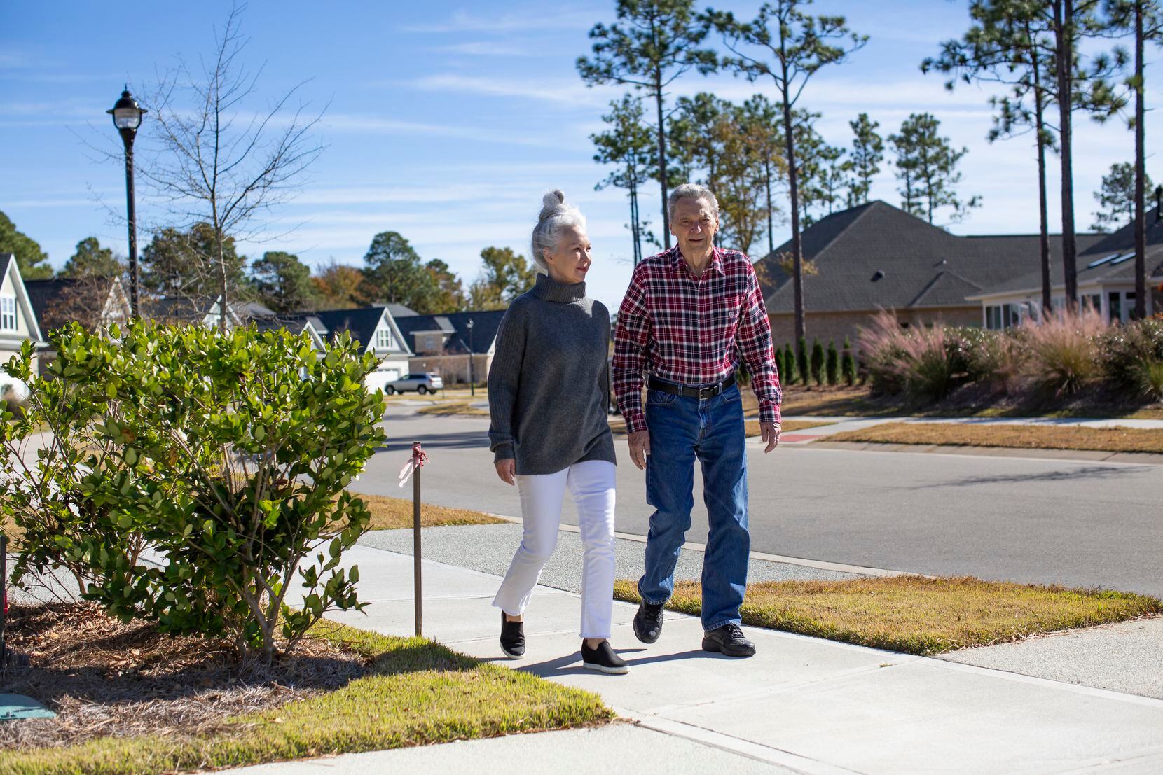 Linda Rounds (left) and her birth father, Gilbert Potyandy, go for a walk near Rounds' half sister's house in Wilmington, N.C., on Thanksgiving Day, Thursday, November 25, 2021. Rounds connected with her birth father while she was helping other Korean adoptees to find their birth families. She and her extended family, including her two half sisters, Gilbert, and his wife, Donna Potyandy, met in Wilmington to celebrate Thanksgiving all together for the first time. 