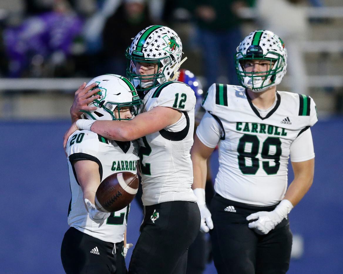 Southlake Carroll quarterback Kaden Anderson (12) hugs running back Zeke Zvonecek (20) after Zvonecek scored a touchdown during the second half of their Class 6A Division I state semifinal playoff game against Duncanville at McKinney ISD Stadium in McKinney, Texas, Saturday, Dec. 11, 2021. Duncanville defeated Southlake Carroll 35-9. (Elias Valverde II/The Dallas Morning News)