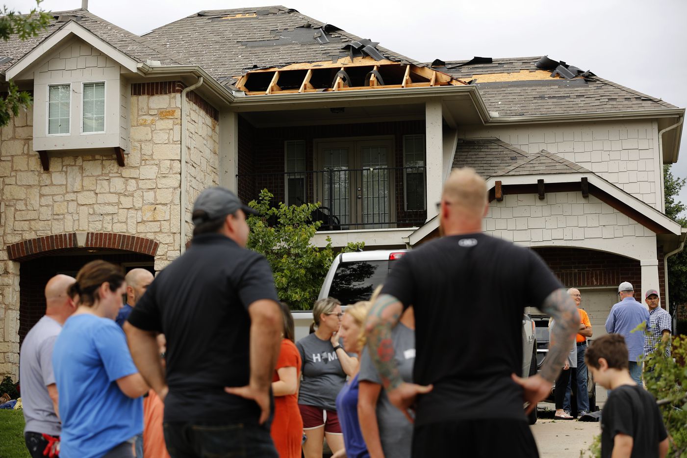 Neighbors visit outside a wind-damaged home on Oliver Dr. in North Fort Worth, after winds toppled trees and torn shingles off of homes, Wednesday, May 29, 2019. A tornado warned storm passed through the neighborhood near Heritage Trace Pkwy and N. Riverside Dr. 