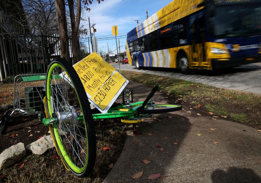 A sign advertising shelled pecans is stuck through an overturned LimeBike on the sidewalk...