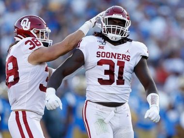 LOS ANGELES, CALIFORNIA - SEPTEMBER 14:  Bryan Mead #38 congratulates Jalen Redmond #31 of the Oklahoma Sooners after his sack of Dorian Thompson-Robinson #1 of the UCLA Bruins during the first half of a game on at the Rose Bowl on September 14, 2019 in Los Angeles, California. (Photo by Sean M. Haffey/Getty Images)