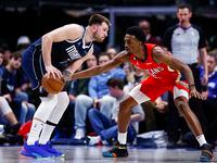 Dallas Mavericks guard Luka Doncic, left, looks for room against New Orleans Pelicans...