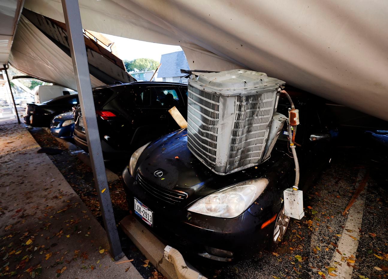 An air conditioner unit of a Waterdance Apartments building and the peeled off roof landed on a car during a tornado-warned storm that rolled through Tuesday night. Damage also occurred at The Mirage Apartments along Pioneer Parkway in Arlington, Wednesday, November 24, 2020.