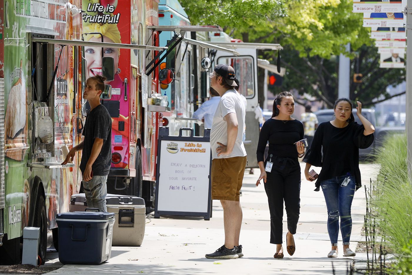 People browse food trucks parked along Woodall Rogers Freeway at Klyde Warren Park on Wednesday, June 23, 2021, in Dallas.