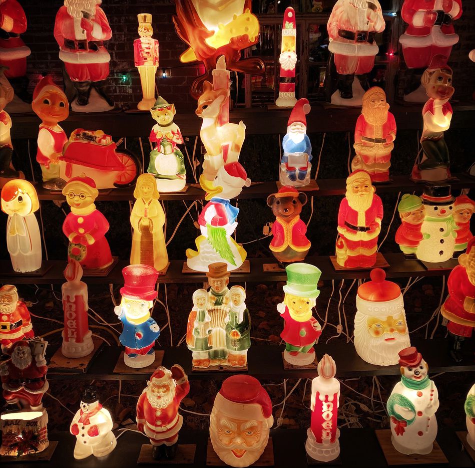 A collection of smaller illuminated Christmas blow molds line risers in Wayne Smith's yard.