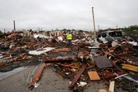 A man is surrounded by tornado damage after severe storms moved through the night before in...