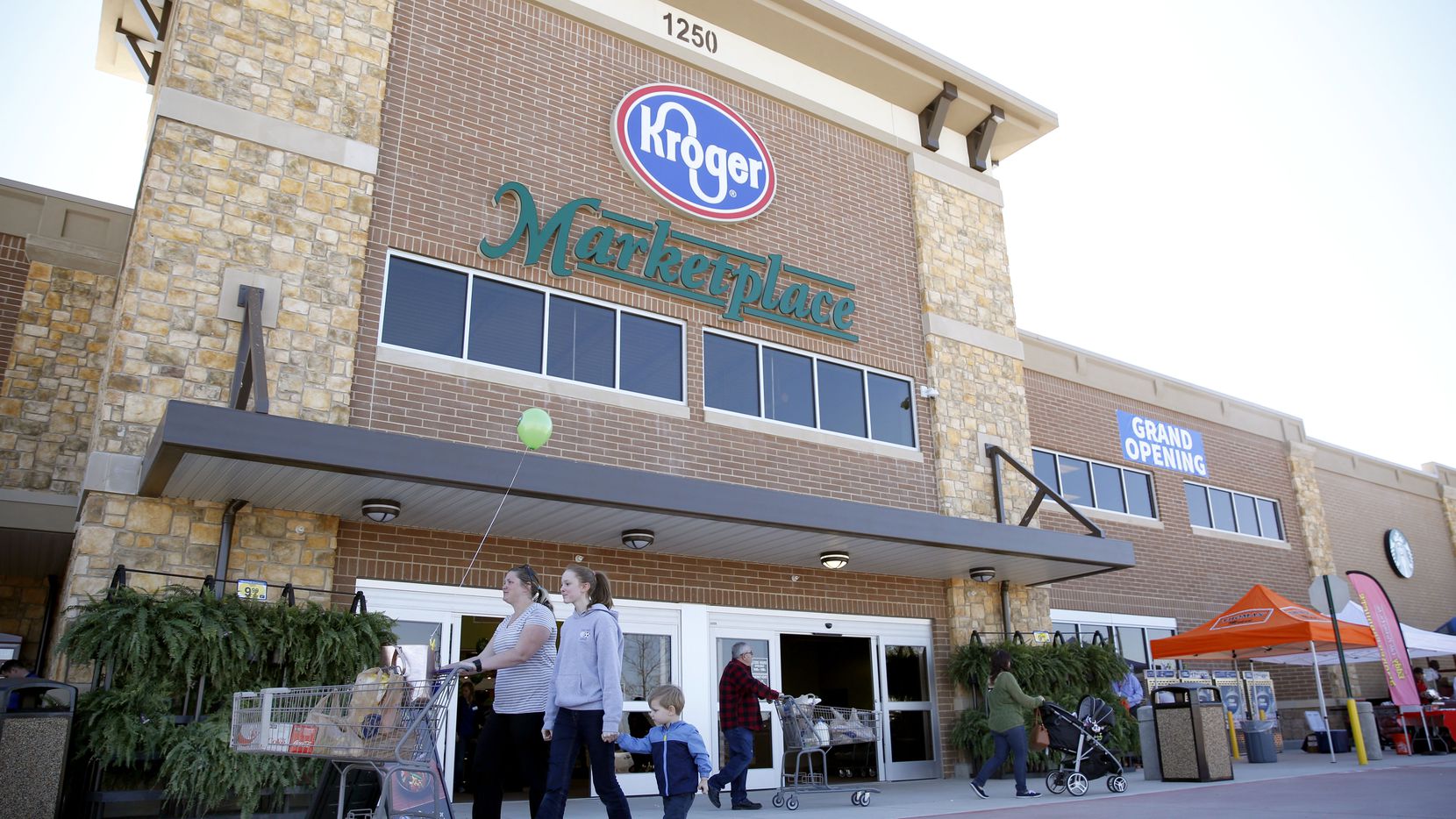 Shoppers walk through the entrance of the new Kroger Marketplace in Prosper.