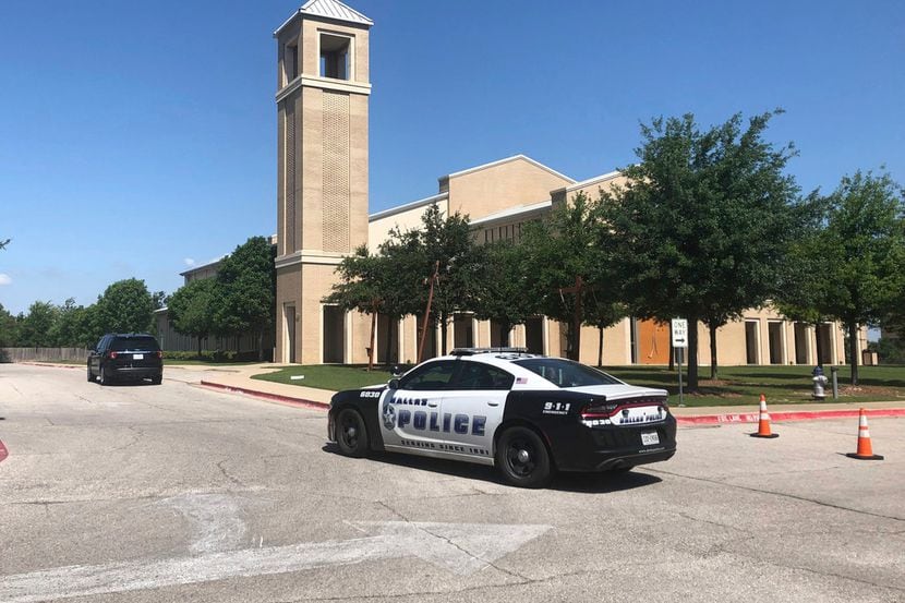 A Dallas police vehicle was parked outside St. Cecilia Catholic Church on West Davis Street...