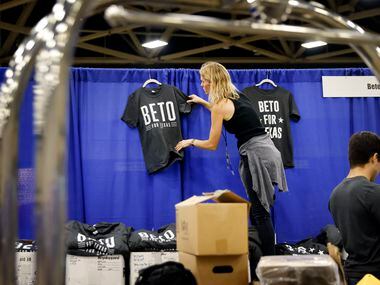 Staffer Chrissy Kleberg hangs up Beto For Texas t-shirts at his booth as the team set up on...