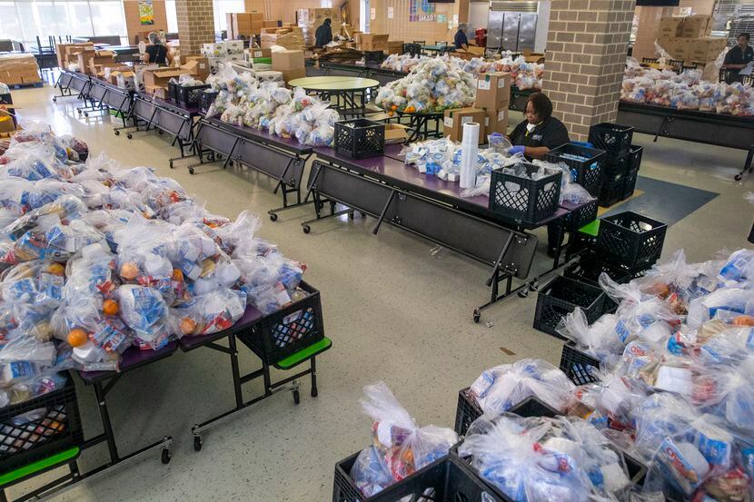 Dallas ISD employees and volunteers prepare bagged breakfast, lunch, and supper meals for...