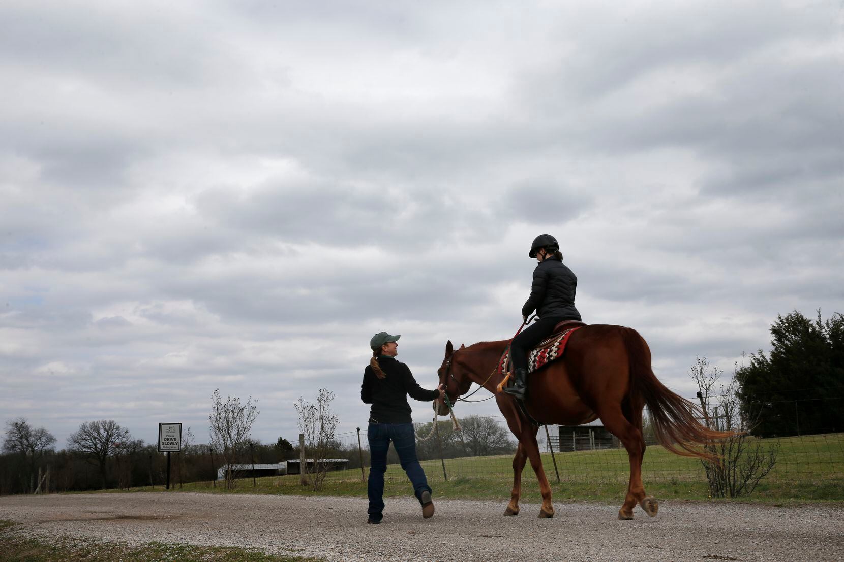 Instructor Antoinette Rand engages with Sara "Happy" Waterman, riding Scooter during equine...