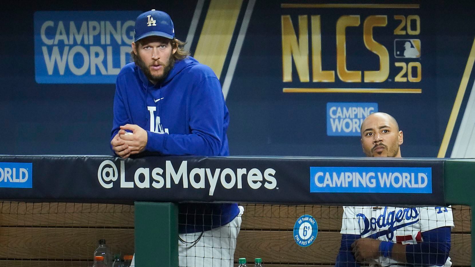 Los Angeles Dodgers starting pitcher Clayton Kershaw (left) watches from the dugout with...
