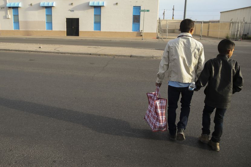 Carlos Joaquin Salinas, 27, of Santa Rosa, Guatamala, crosses the street with his son...