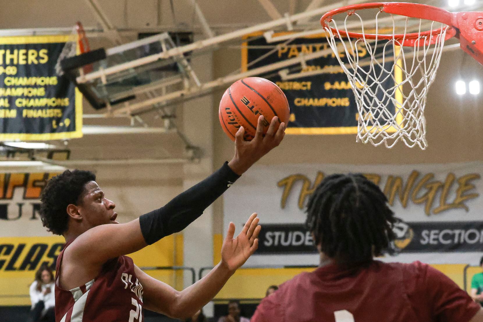 Plano Senior High School’s Justin McBride (21) jumps to score a two-pointer during the game...