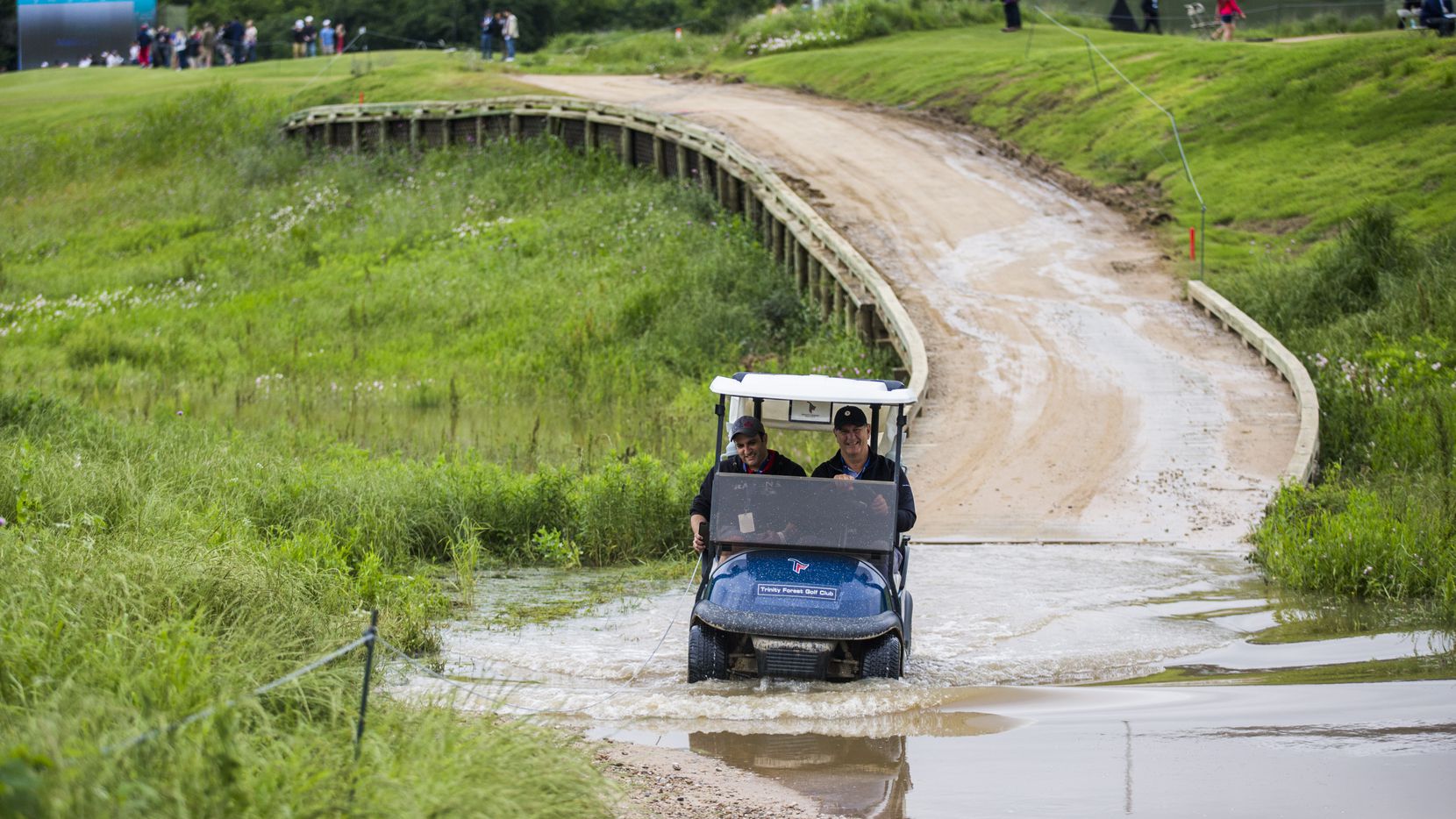 Mayor Mike Rawlings drives a golf cart through a large puddle near hole 12 during round 3 of...