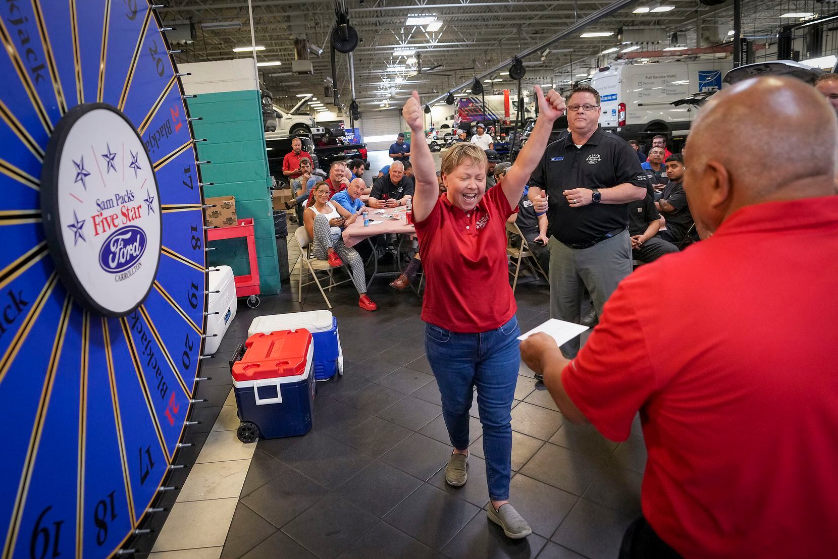 Jamie Cory celebrates after winning a cash prize with the spin of a wheel during a shop...