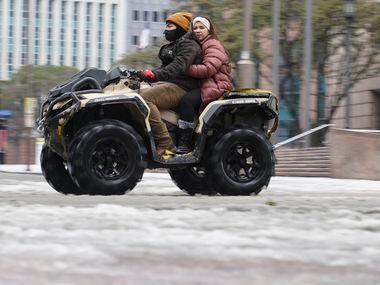 A person drives a four wheeler with other motorist through downtown, Wednesday, Feb. 1,...
