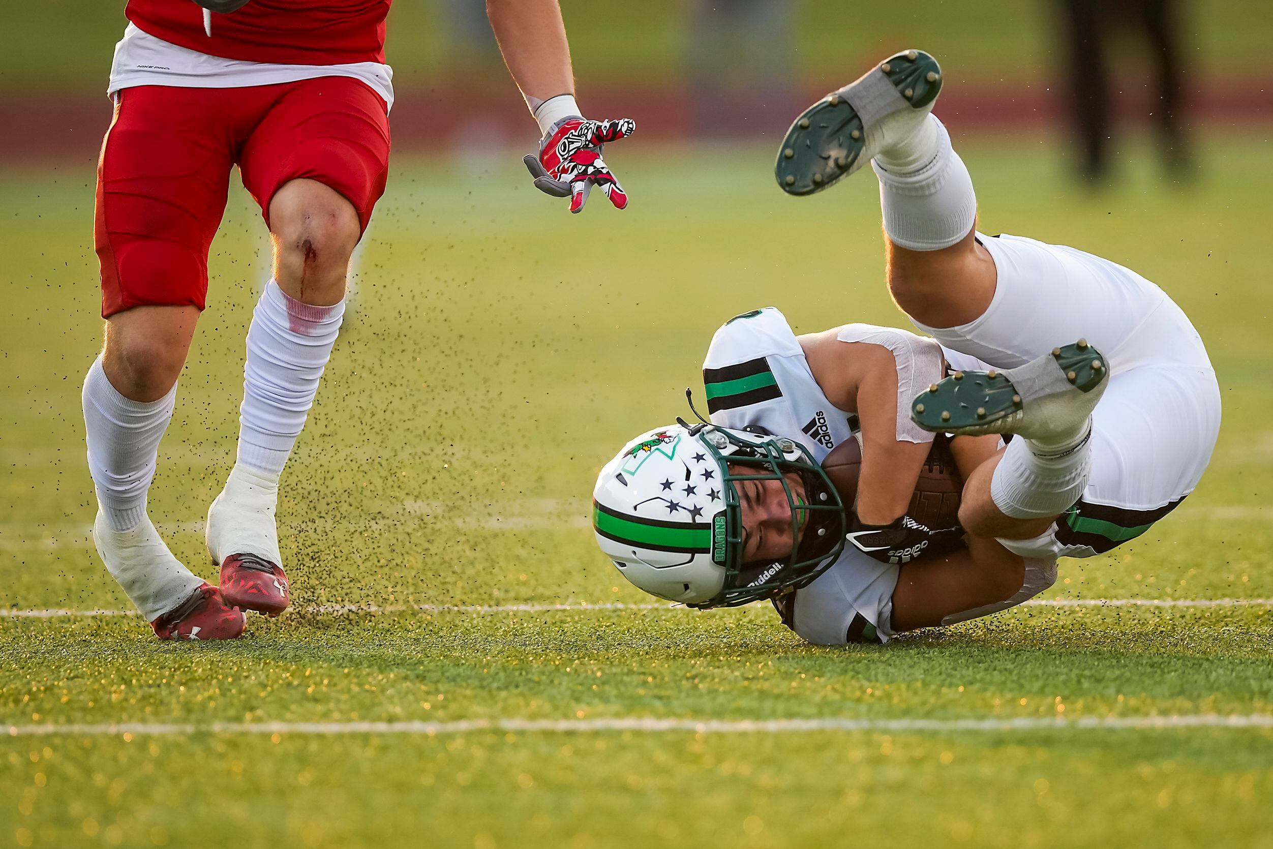 Southlake Carroll wide receiver Owen Ohser (4) tumbles to the turf with a reception during...