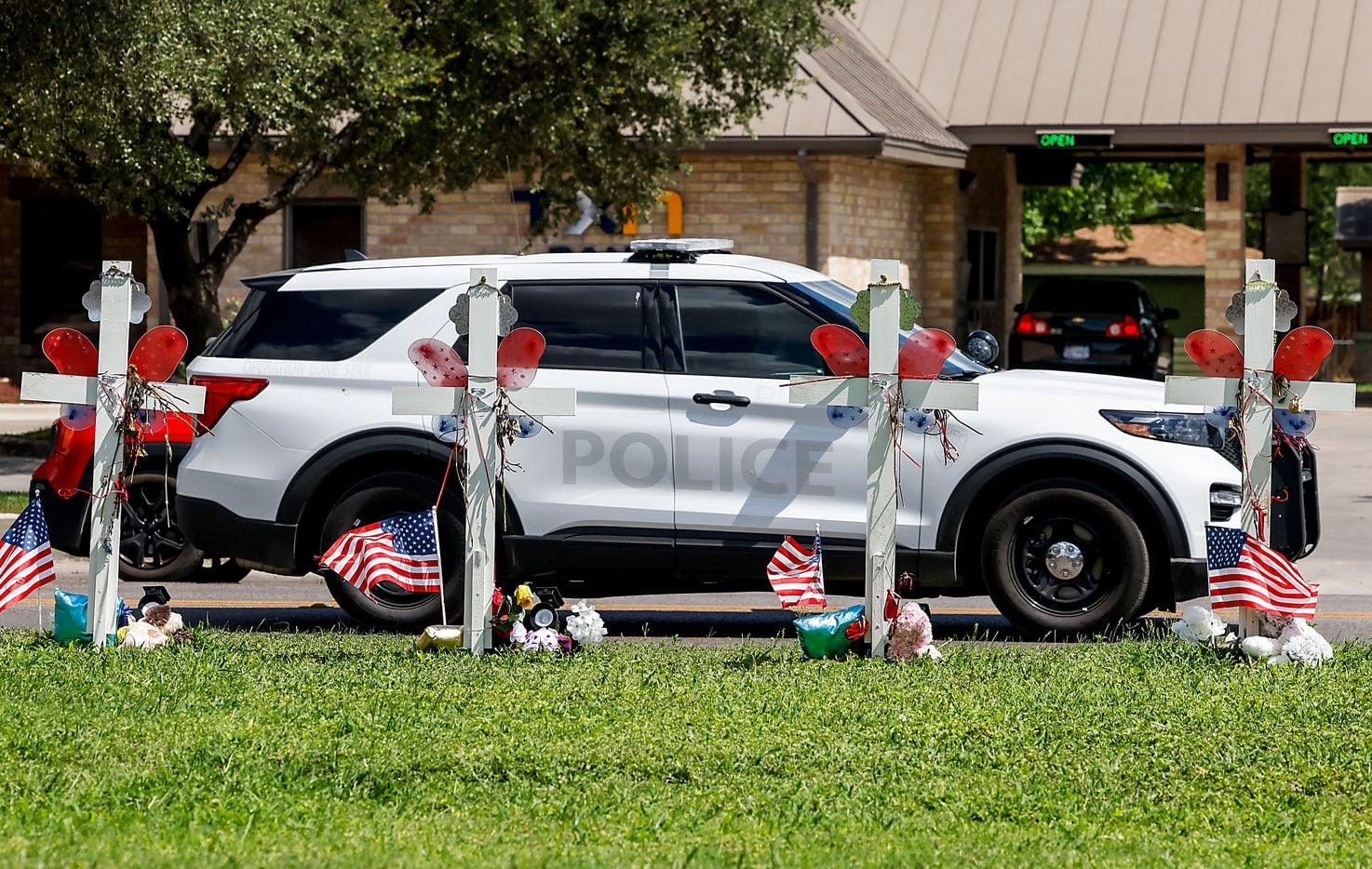 An Operation Lone Star Police car passes by a memorial in honor of the 21 victims, 19...