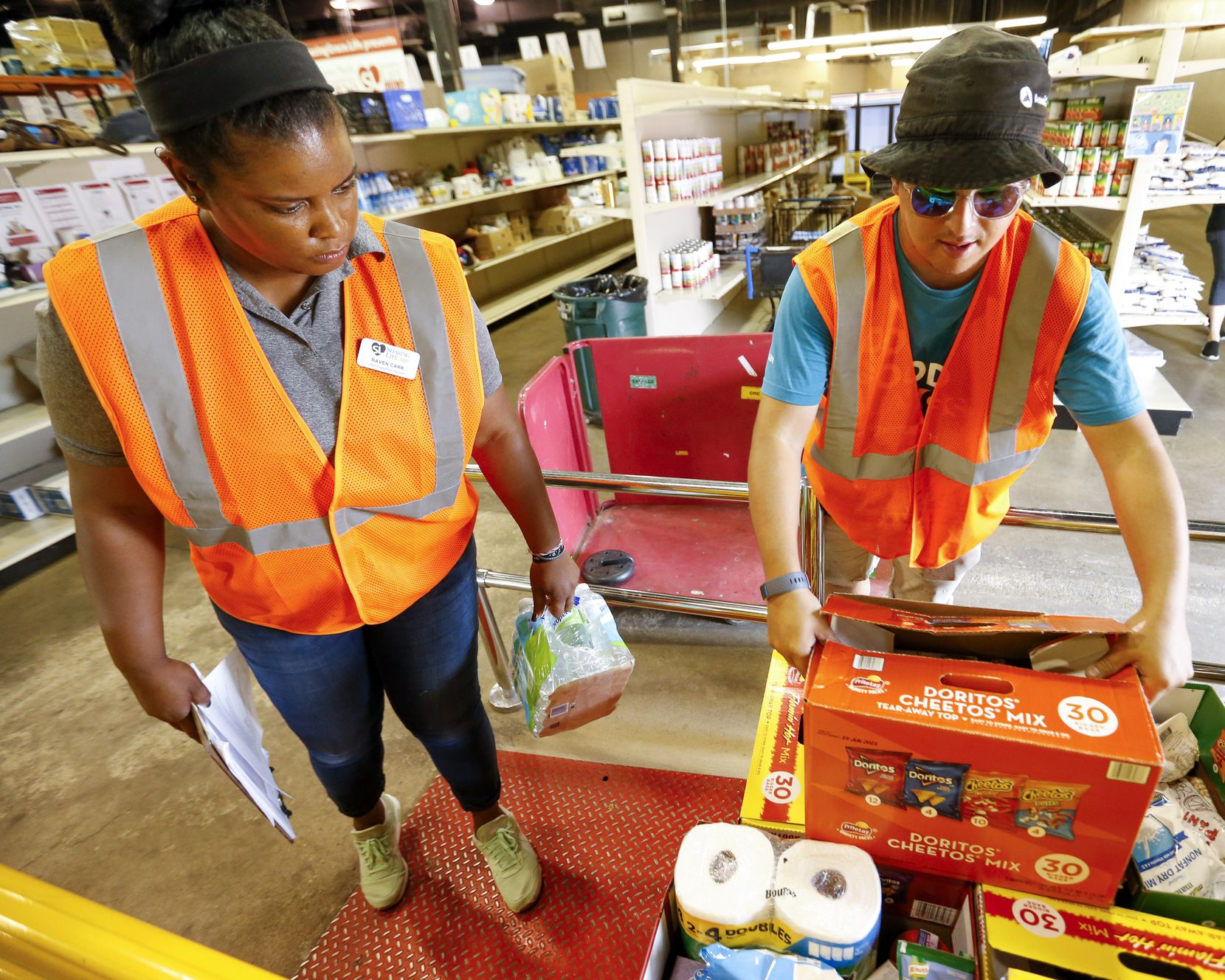 Raven Carr (left) and Eric Gallarza weigh food donations at Sharing Life Community Outreach in Mesquite.