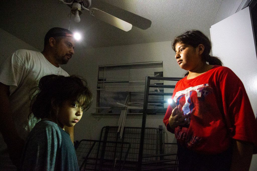 Antonio Gonzalez (izquierda) y sus hijas Naia (izquierda abajo), 5, and Giovanna, 14, inspeccionan su hogar en la calle Glenrio Lane después del paso de un tornado por el norte de Dallas el domingo 20 de octubre.