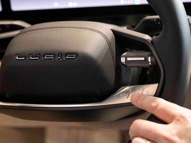 Zak Edson, VP Sales and Service at Lucid, points to the steering wheel control of the Air...