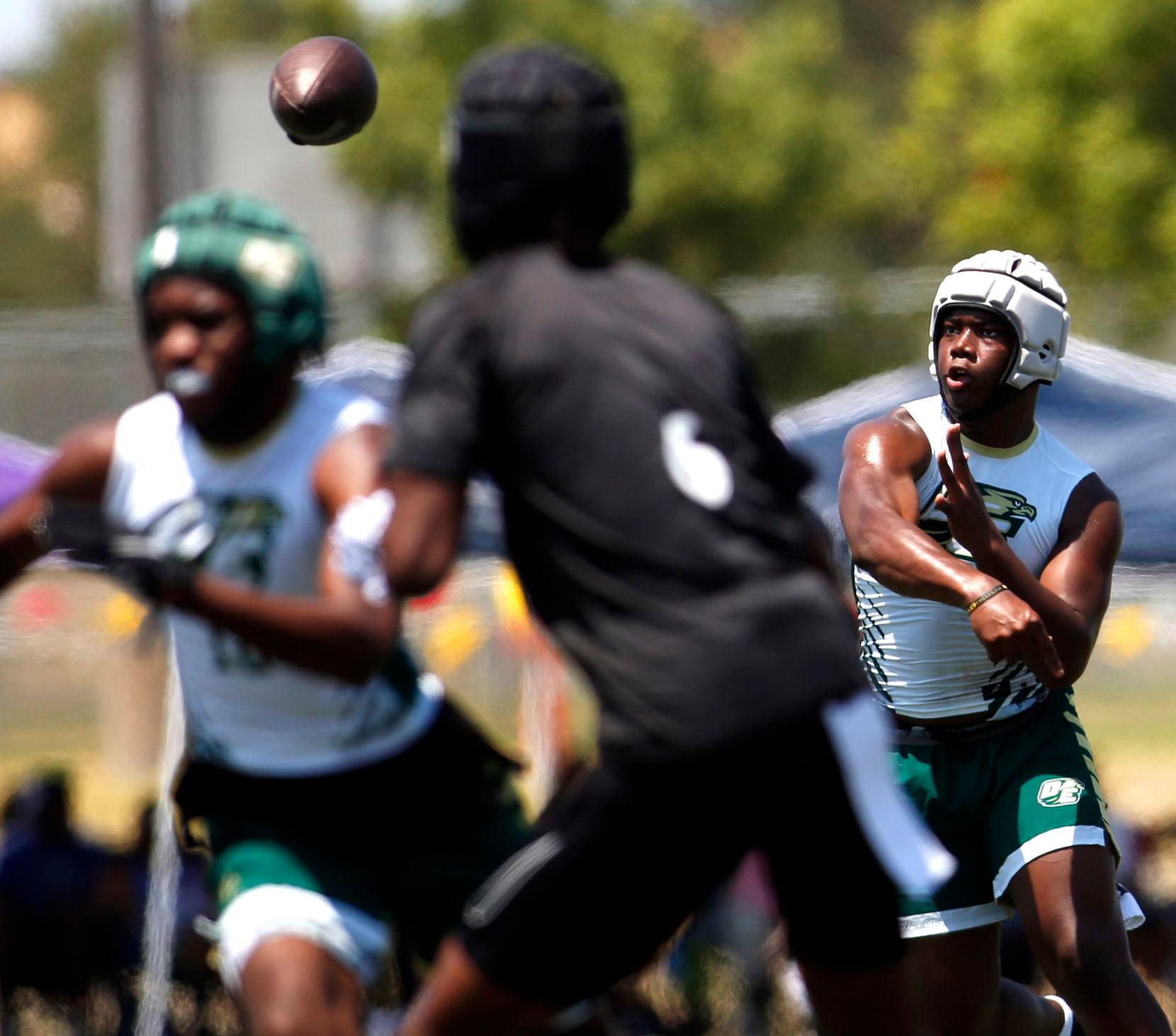 DeSoto Eagles quarterback DJ Bailey (5), right, launches a pass downfield for a receiver...