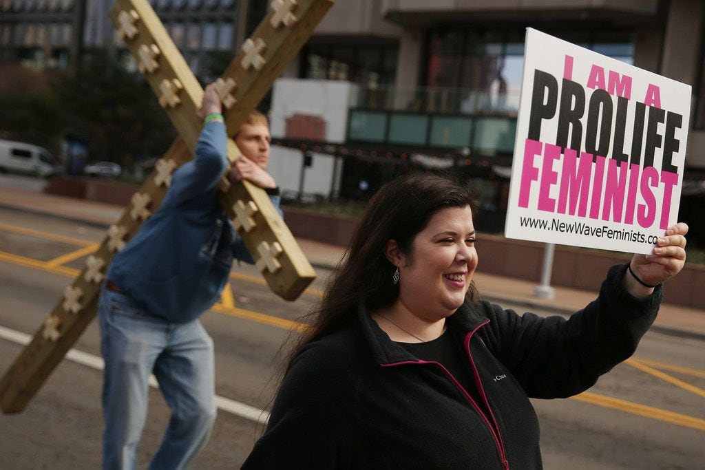 Rachel Lamb, of Richardson, Texas, who is part of the group New Wave Feminists, walks as...
