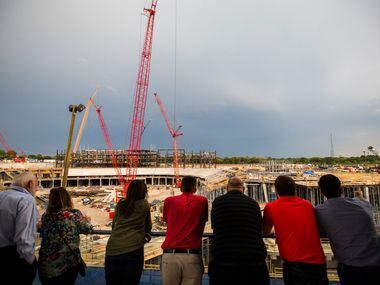 Guests look over the construction of the new stadium for the Texas Rangers from the balcony...