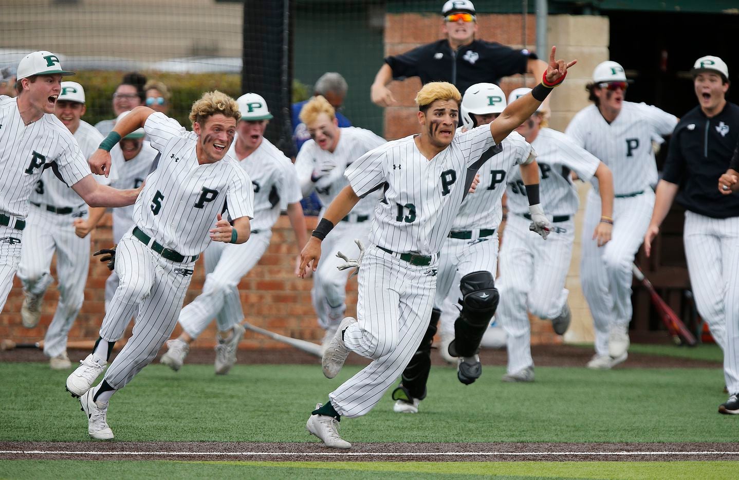 Gabriel Colina (13) leads his team sprinting out of the dugout after completing a come from...