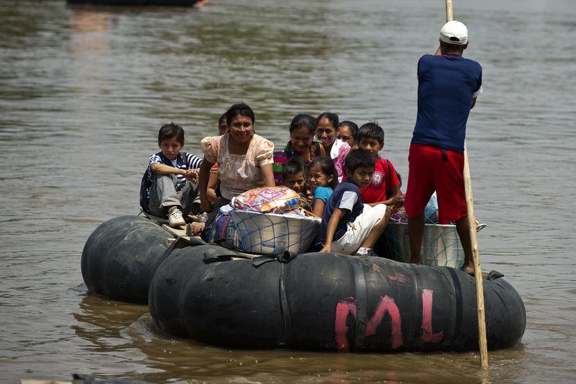 Una balsa improvisada con personas cruzan la frontera de Guatemala con México de manera...