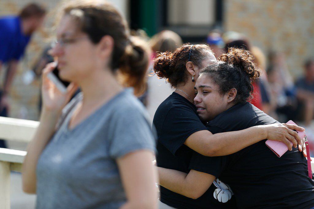 Santa Fe High School junior Guadalupe Sanchez, 16, cries in the arms of her mother, Elida...