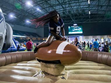 Laceon Donaldson, 11, rides a mechanical football during the Dallas Cowboys' 2017 NFL Draft...