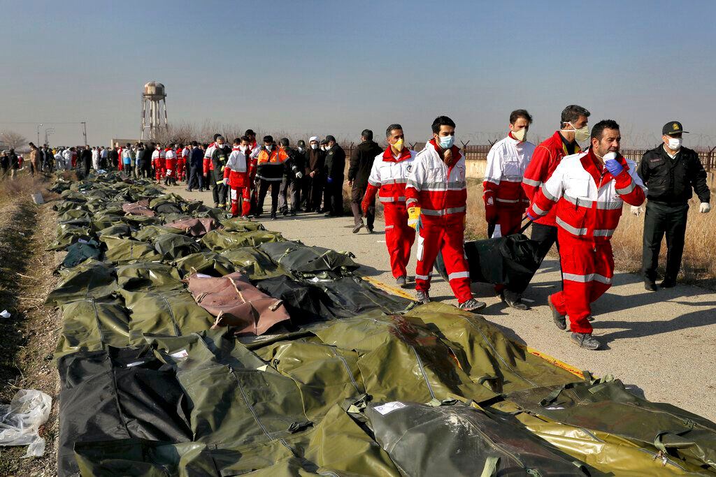 ARCHIVO - En esta foto de archivo del 8 de enero de 2020, rescatistas cargan el cuerpo de...
