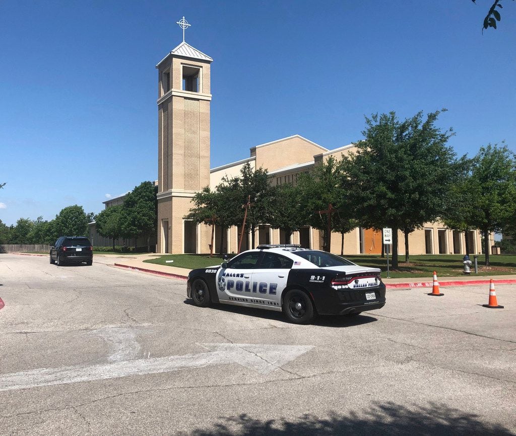 A Dallas police vehicle was parked outside St. Cecilia Catholic Church on West Davis Street...