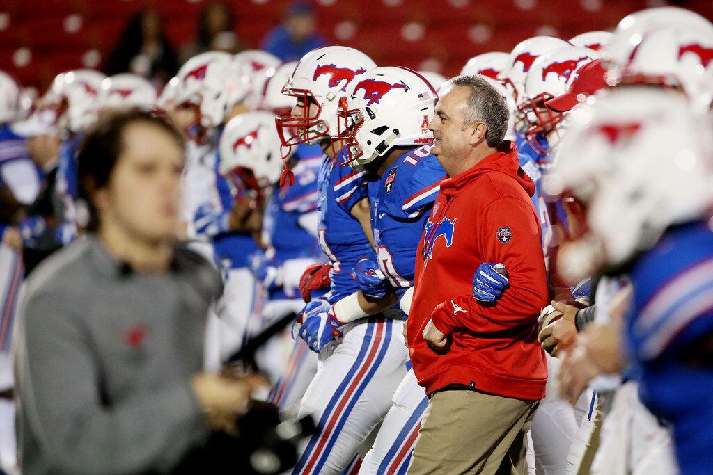 New Southern Methodist Mustangs head coach Sonny Dykes walks with his team before the NCAA...