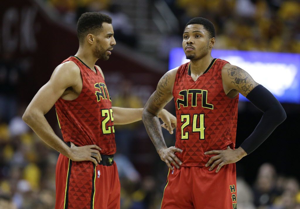 Atlanta Hawks forward Thabo Sefolosha (25) talks with forward Kent Bazemore (24) during a break in play in the first half against the Cleveland Cavaliers during Game 2 of a second-round NBA basketball playoff series, Wednesday, May 4, 2016, in Cleveland. (AP Photo/Tony Dejak)