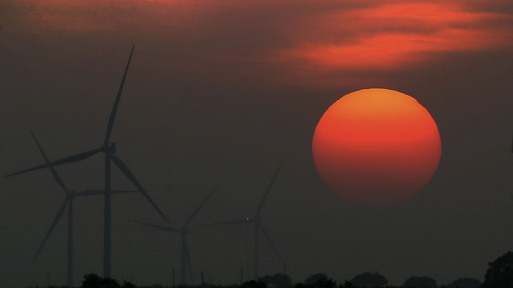 The sun sets at windmill farm in McCook, Texas. (Delcia Lopez/The Monitor via AP)