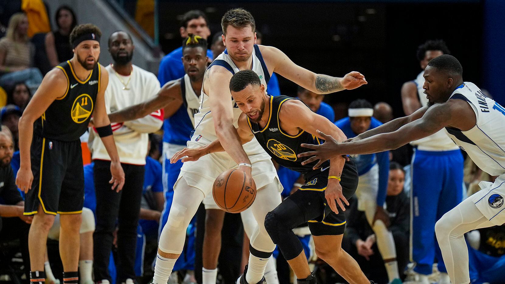 Dallas Mavericks guard Luka Doncic (77) tries to steal the ball from Golden State Warriors...