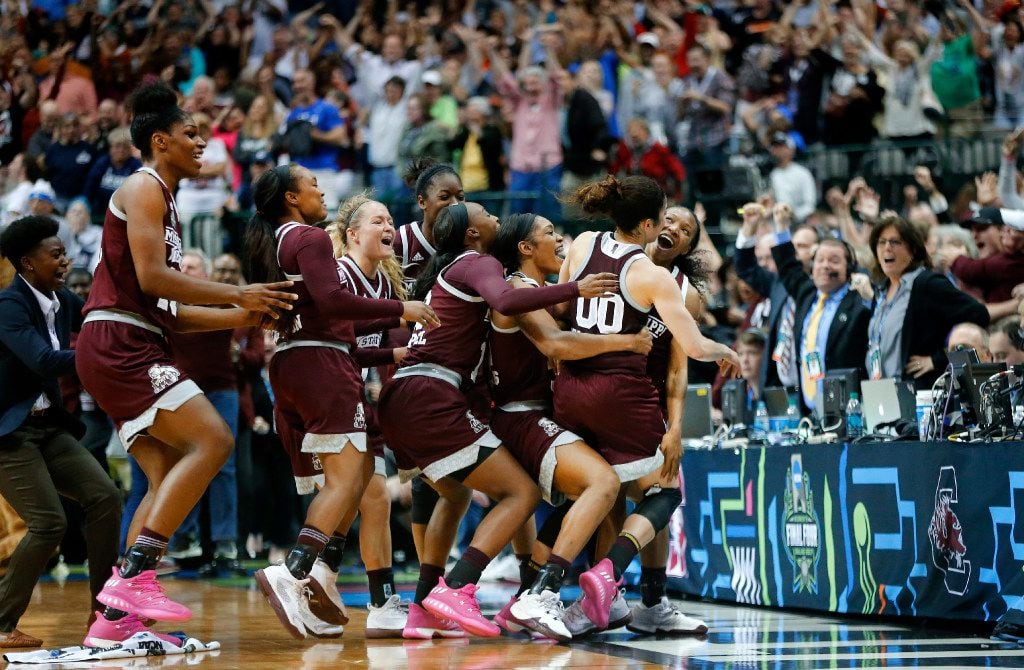 Mississippi State Lady Bulldogs guard Morgan William (2, right) is mobbed by teammates after...
