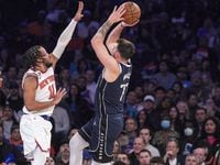 Dallas Mavericks guard Luka Doncic, right, shoots over New York Knicks guard Jalen Brunson,...