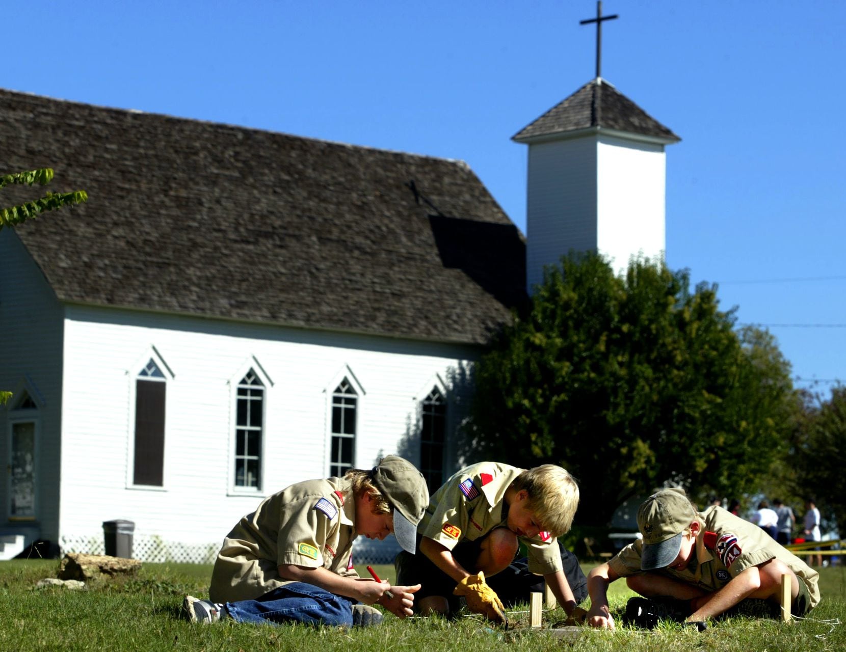 Members of Boy Scout Troop 714 dig for artifacts at the former Frankford town site at 17405 Muirfield Drive located near the intersection of the Dallas North Tollway and Frankford Road. Behind the scouts is the Church of the Holy Communion and Episcopal church. (Oct. 18, 2003)