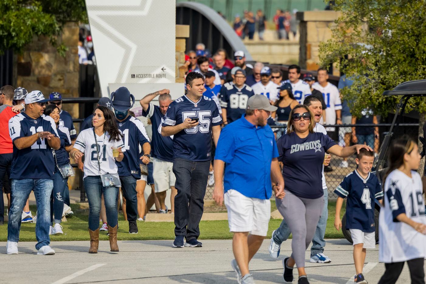 Fans cross over Johnson Creek from Texas Live! before the start of the Cowboys game against...